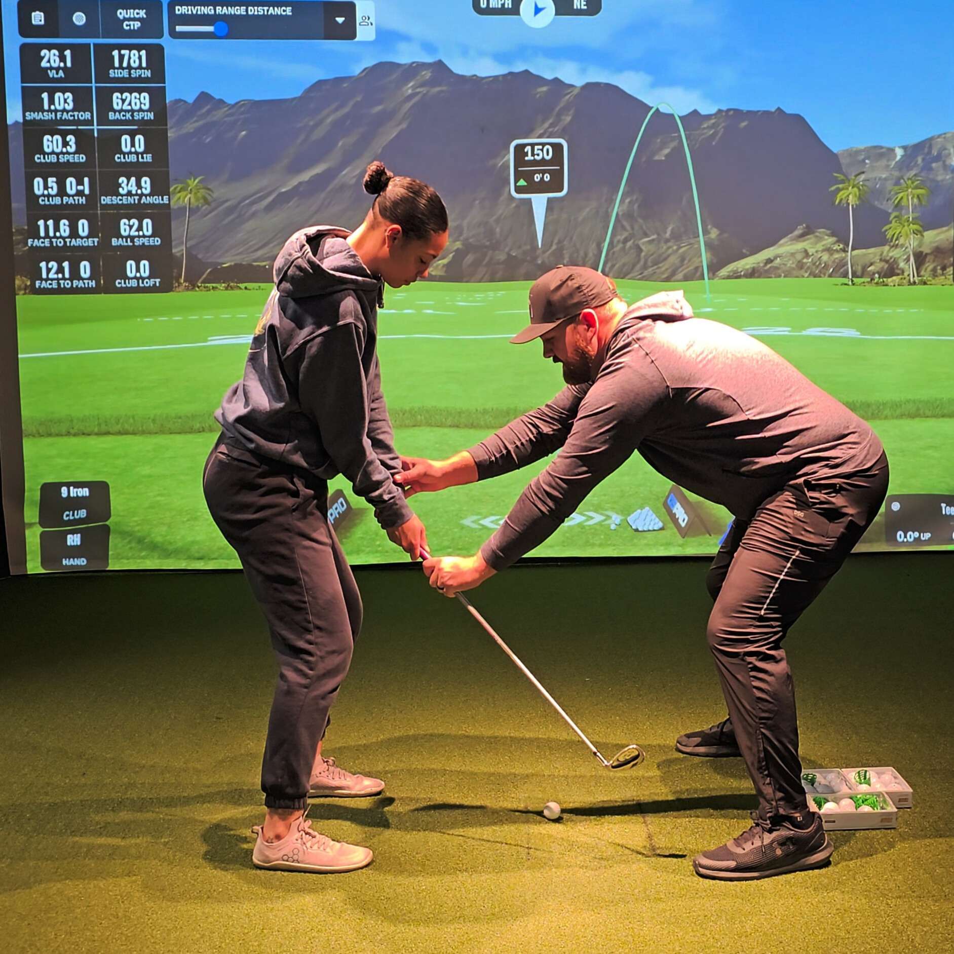 katara Golf instructor teaching student swing indoors simulator
